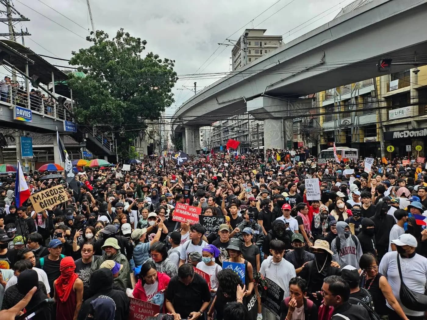 Massive crowd of protesters filling a Manila street under the LRT line on 21 September 2025